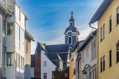 Church tower in wetzlar with a clock is rising above colorful buildings in a small european town clipart