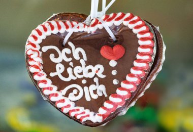 Paketlenmiş kalp şeklinde zencefilli çörek ve Alman 'ın yazdığı ich liebe dich (seni seviyorum) geleneksel bir Noel pazarında asılı.