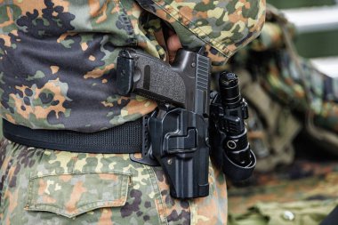 Kamuflaj üniformalı kılıflı silahlı bir asker..