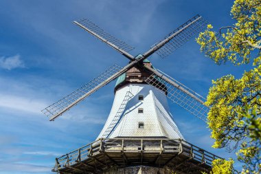 Gökyüzüne uzanan tarihi Alman yel değirmeni güneşli bir günde geleneksel mimari ve mühendislik sergiliyor..