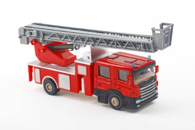 Merdiveni genişleten kırmızı ve gri oyuncak itfaiye aracı, beyaz arka planda izole edilmiş, oyun zamanı veya eğitim amaçlı olarak hazır..