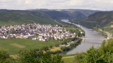 Moselle nehri boyunca uzanan, üzüm bağlarıyla çevrili, hoş bir viraj boyunca uzanan, pitoresk bir Alman kasabasında nefes kesici manzara gözler önüne seriliyor.