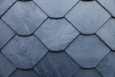 Üst üste binen çatı kiremitleri desenli desenler oluşturur, ev inşaatında el işçiliği gösterilir