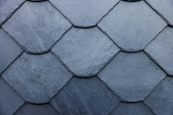 Üst üste binen çatı kiremitleri desenli desenler oluşturur, ev inşaatında el işçiliği gösterilir