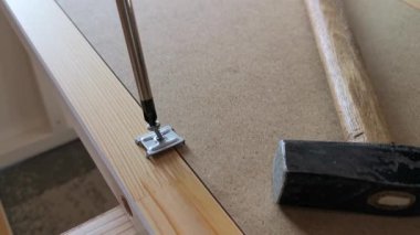 Bir marangozun ahşap bir tahtanın vidasını tornavidayla sıkarken yakın çekimi.