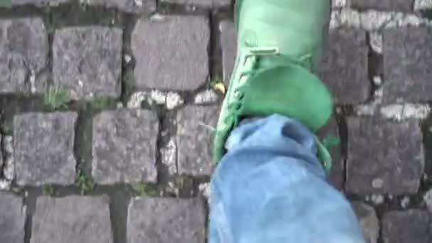 男子穿着绿色的鞋子和牛仔裤在人行道上散步时的特写镜头 — 图库视频影像