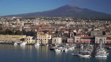 Catania Limanı. Beyaz dumanlı ve arka planında mavi gökyüzü olan volkan Etna. Sicilya, İtalya.