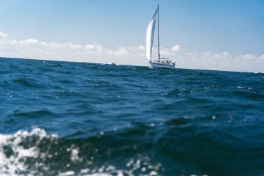 Gökyüzünde bulutlar olan açık denizde yelkenli. Seyahat, macera ve tatil kavramı