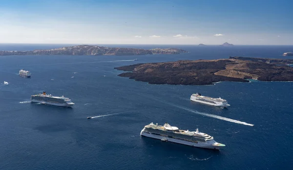 Many luxury cruise ships anchored by island in blue water. Travel, voyage and vacation concept.