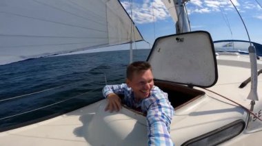 Genç denizci, açık denizde yelkenlilerden selfie kaydediyor. Seyahat, macera konsepti.