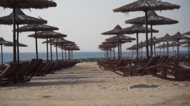 Sahilde birçok şemsiye ve güneş sandalyesi, tatiller için sembolik fotoğraf, seyahat, güneş yanığı, tatil
