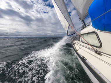 Yelkenli açık denizde fırtına ve dalgalarla savaşır. Seyahat, macera, risk ve tehlike kavramı.