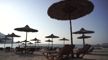 Sahilde birçok şemsiye ve güneş sandalyesi, tatiller için sembolik fotoğraf, seyahat, güneş yanığı, tatil