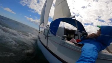 Genç denizci açık denizde dalgalı bir yelkenliden selfie kaydediyor. Seyahat, macera konsepti.