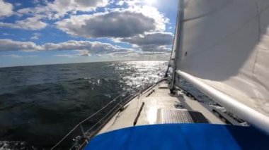 Gün batımında yelkenli, dalgaları yavaş çekimde kesiyor. Seyahat, macera, tatil kavramı.