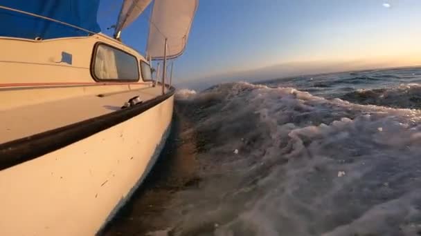 ゆっくりとした動きで波を切断海で日没時の帆船 休暇の概念 — ストック動画