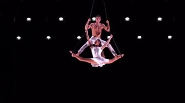 Siyah sahne arkasında beyaz kostümlü hava kayışlı ikili performans sergiliyor. Yüksek kaliteli FullHD görüntüler