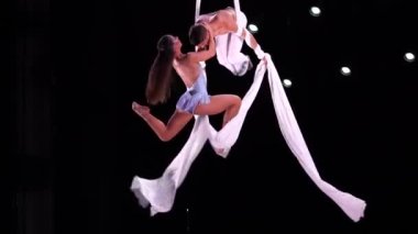 Siyah sahne arkasında beyaz kostümlü hava kayışlı ikili performans sergiliyor. Yüksek kaliteli FullHD görüntüler