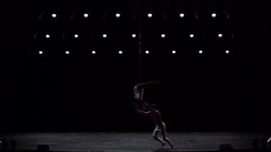 Siyah sahne arkasında beyaz kostümlü hava kayışlı ikili performans sergiliyor. Yüksek kaliteli FullHD görüntüler