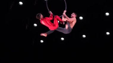 Siyah arka planda hava çemberi ikilisi performans sergiliyor. Çiftte romantik ilişki kavramı.