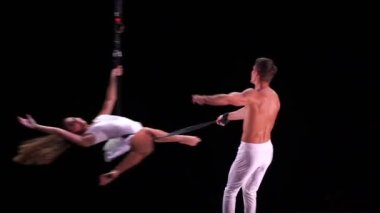 Siyah sahne arkasında beyaz kostümlü hava kayışlı ikili performans sergiliyor. Yüksek kaliteli FullHD görüntüler