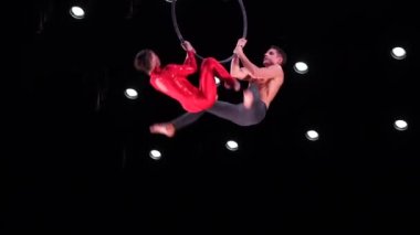 Siyah arka planda hava çemberi ikilisi performans sergiliyor. Çiftte romantik ilişki kavramı.
