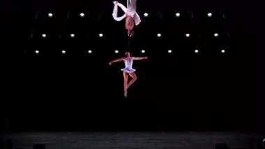 Siyah sahne arkasında beyaz kostümlü hava ipek ikilisi performans sergiliyor. Yüksek kaliteli FullHD görüntüler