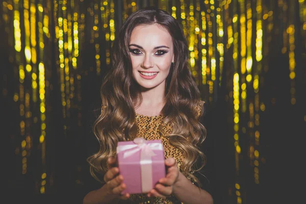 Mulher Atraente Com Caixa Presente Rosa Fundo Dourado — Fotografia de Stock