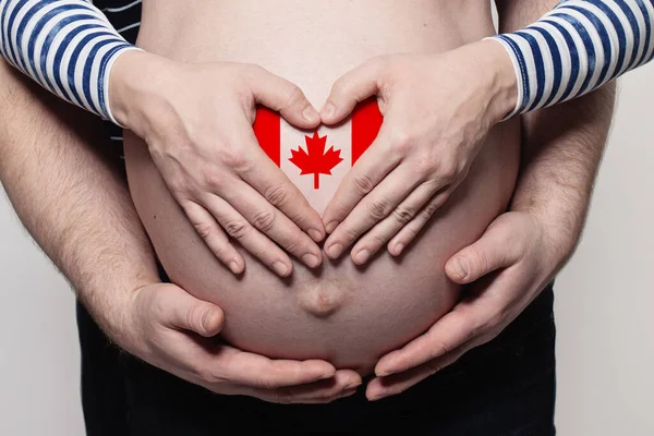 加拿大家庭概念 男子抱着孕妇的肚子和心脏与加拿大国旗的颜色特写 — 图库照片