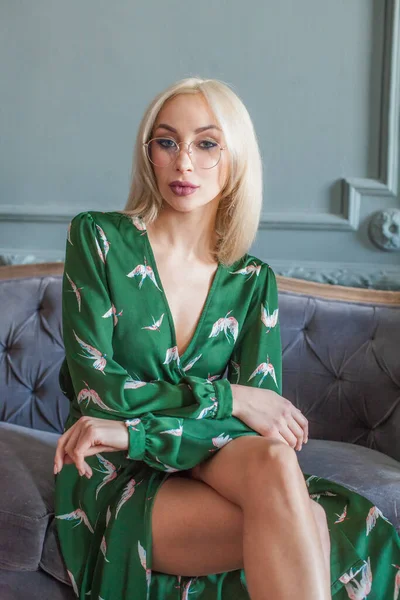 Beautiful Blond Woman Makeup Green Dress Glasses Sitting Grey Velvet — Stock Photo, Image