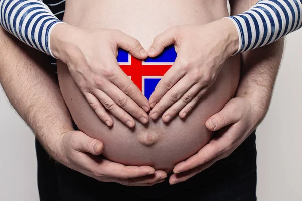 冰岛家庭概念 男子抱着身披冰岛国旗的孕妇肚子和心脏特写 — 图库照片