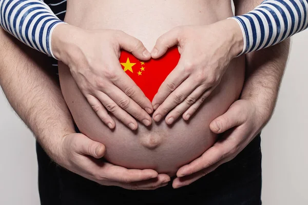 中国家庭观念 男子拥抱着身披中国国旗的孕妇肚子和心脏特写 — 图库照片