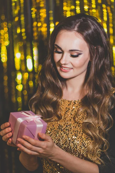 Beautiful Woman Holding Gift Golden Bokeh Background — Stock Photo, Image