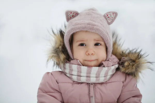 Portrait of girl in pink winter coat with fur outdoor