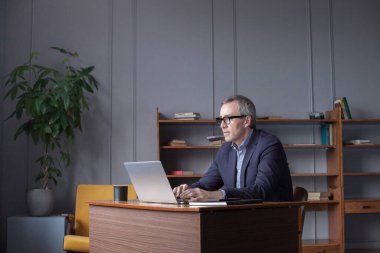 Skilled man programmer developing application software and using laptop computer and a notebook to record-keeping. 