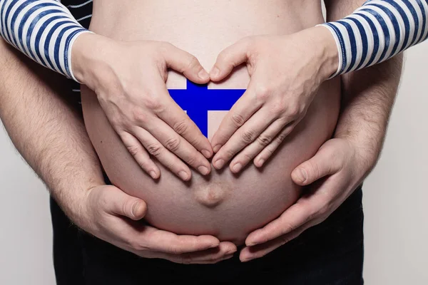 フィンランドの家庭概念 フィンランドの色の旗で妊娠中の女性の腹と心を受け入れる男が閉じ — ストック写真