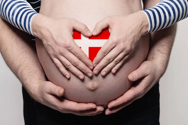 Dánský Rodinný Koncept Muž Objímající Těhotnou Ženu Břicho Srdce Vlajkou — Stock fotografie