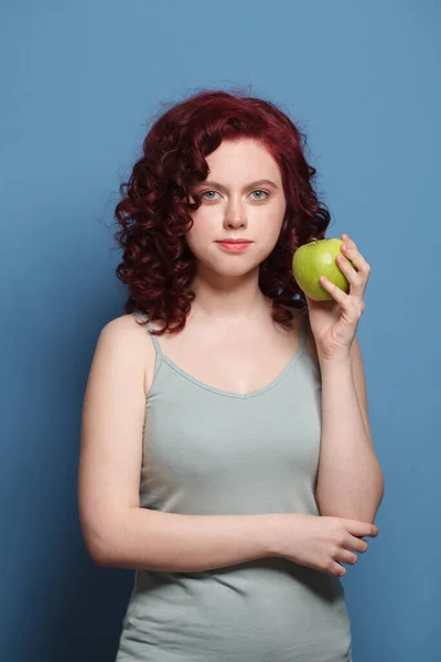 Гламурная Женщина Рыжими Вьющимися Волосами Сером Топе Держит Зеленое Яблоко — стоковое фото