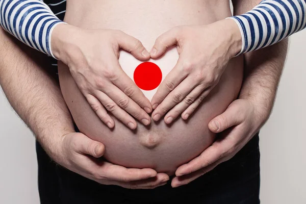 Japonský Rodinný Koncept Muž Objímající Těhotnou Ženu Břicho Srdce Vlajkou — Stock fotografie