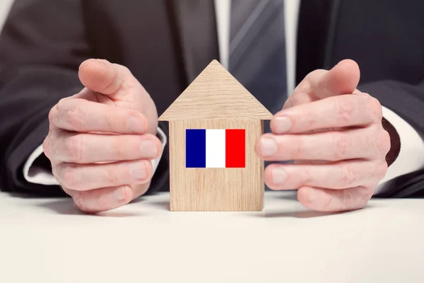 Pengusaha Tangan Memegang Kayu Model Rumah Dengan Bendera Prancis Konsep — Stok Foto