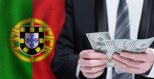 stock image Hands holding dollar money on flag of Portugal