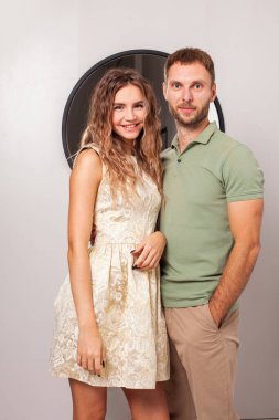 Ayna ve stüdyo duvarının önünde duran çift.