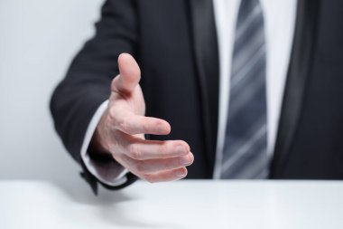 Businessman hand in suit, handshake on blurred white background. Partnership, deal and agreement concept