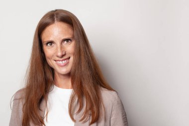 Cheerful woman face. Cute mid adult model with long healthy brown hair smiling