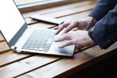 Hand with laptop closeup. Businessman working on laptop
