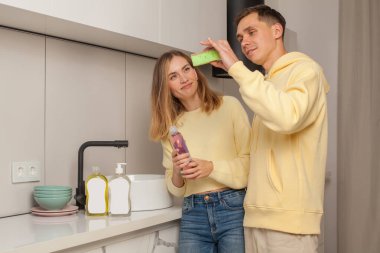Man and woman looking on dishwashing liquid with blank label