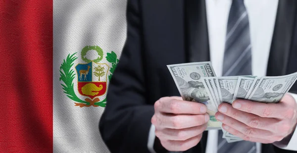 Hands holding dollar money on flag of Peru