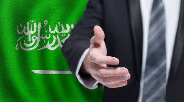 Saudi Arabia business, politics, cooperation and travel concept. Hand on flag of Saudi Arabia background.
