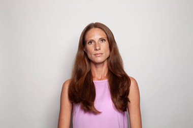 Gerçek kadın portresi. Beyaz arka planda uzun kahverengi saçlı olgun bir kadın.