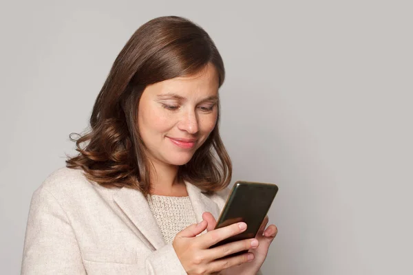 若いブルネットの女性を笑顔携帯電話を使用して Smsメッセージを入力 肖像画 — ストック写真